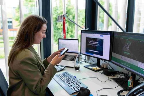 Jolien ten Broeke looks at her mobile phone at her desk in Sasma's headquarters