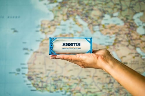 A model tank with the Sasma logo on it in front of a map of the world