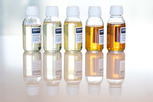 A line of five sample bottles filled with deeper and deeper shares of amber alcohol