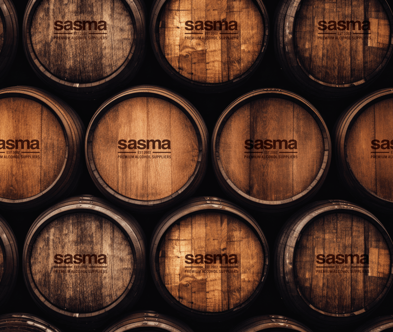 A stack of wooden barrels with the Sasma logo stamped on the end.